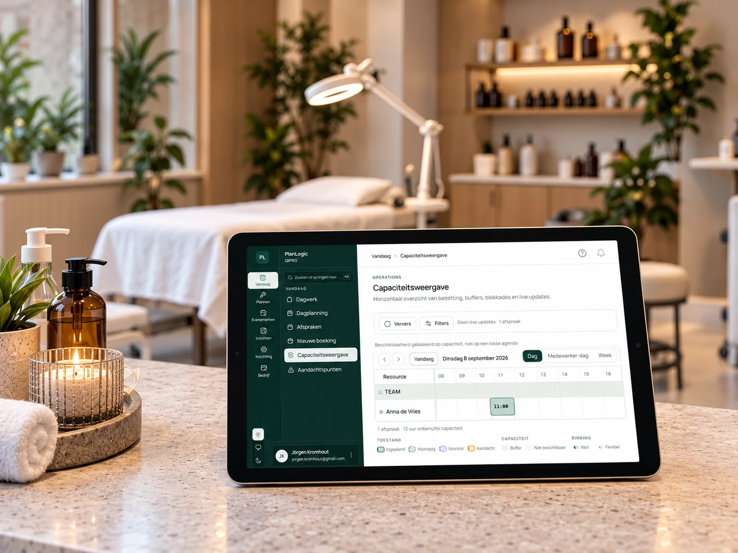 Balie van een beautysalon met de capaciteitsweergave van PlanLogic op een tablet, behandelbed en apparatuur op de achtergrond